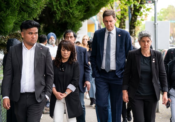 British Columbia Premier David Eby, second from right, and Member of the Legislative Assembly of B.C., Mable Elmore, walk with members of the Filipino community to a press conference after a vehicle drove into a crowd during a Lapu Lapu Day festival in Vancouver, British Columbia, Sunday, April 27, 2025. (Rich Lam/The Canadian Press via AP)