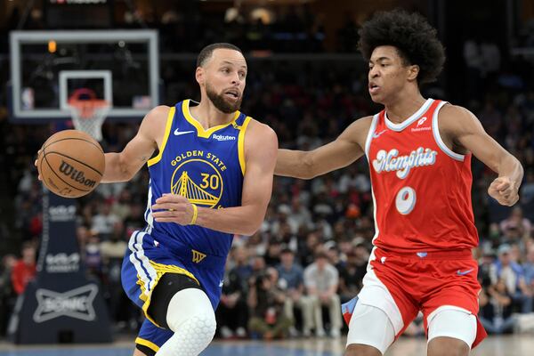 Golden State Warriors guard Stephen Curry (30) drives against Memphis Grizzlies forward Jaylen Wells (0) in the first half of an NBA basketball game, Tuesday, April 1, 2025, in Memphis, Tenn. (AP Photo/Brandon Dill)