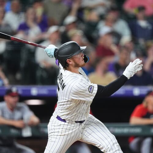Colorado Rockies' Hunter Goodman follows the flight of his solo home run off Washington Nationals relief pitcher Clayton Beeter in the eighth inning of a baseball game Tuesday, July 21, 2026, in Denver. (AP Photo/David Zalubowski)