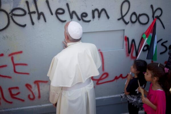 FILE - Pope Francis prays at Israel's separation barrier on his way to a mass in Manger Square next to the Church of the Nativity, traditionally believed to be the birthplace of Jesus Christ in the West Bank city of Bethlehem on Sunday, May 25, 2014. (AP Photo/Ariel Schalit, File)