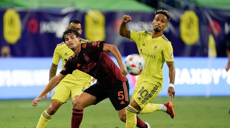 Atlanta United's Santiago Sosa (5) and Nashville SC's Hany Mukhtar (10) vie for the ball during the first half of an MLS soccer match Thursday, July 8, 2021, in Nashville, Tenn. (AP Photo/Mark Humphrey)