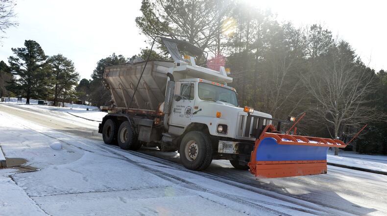 A Dekalb County sand truck spreads salt and sand along Snapfinger Woods Drive near Miller Road Wednesday. The Atlanta metro area continues to suffer under the grip of snow and ice covered roads for a second day Wednesday, January 29, 2014, after a mid-day storm paralyzed the area Tuesday.
