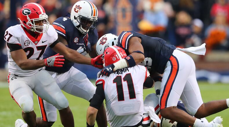 Georgia quarterback Jake Fromm is tackled by Auburn defenders breaking up a play for no gain during the first half in a NCAA college football game at Jordan-Hare Stadium on Saturday, November 11, 2017, in Auburn.    Curtis Compton/ccompton@ajc.com