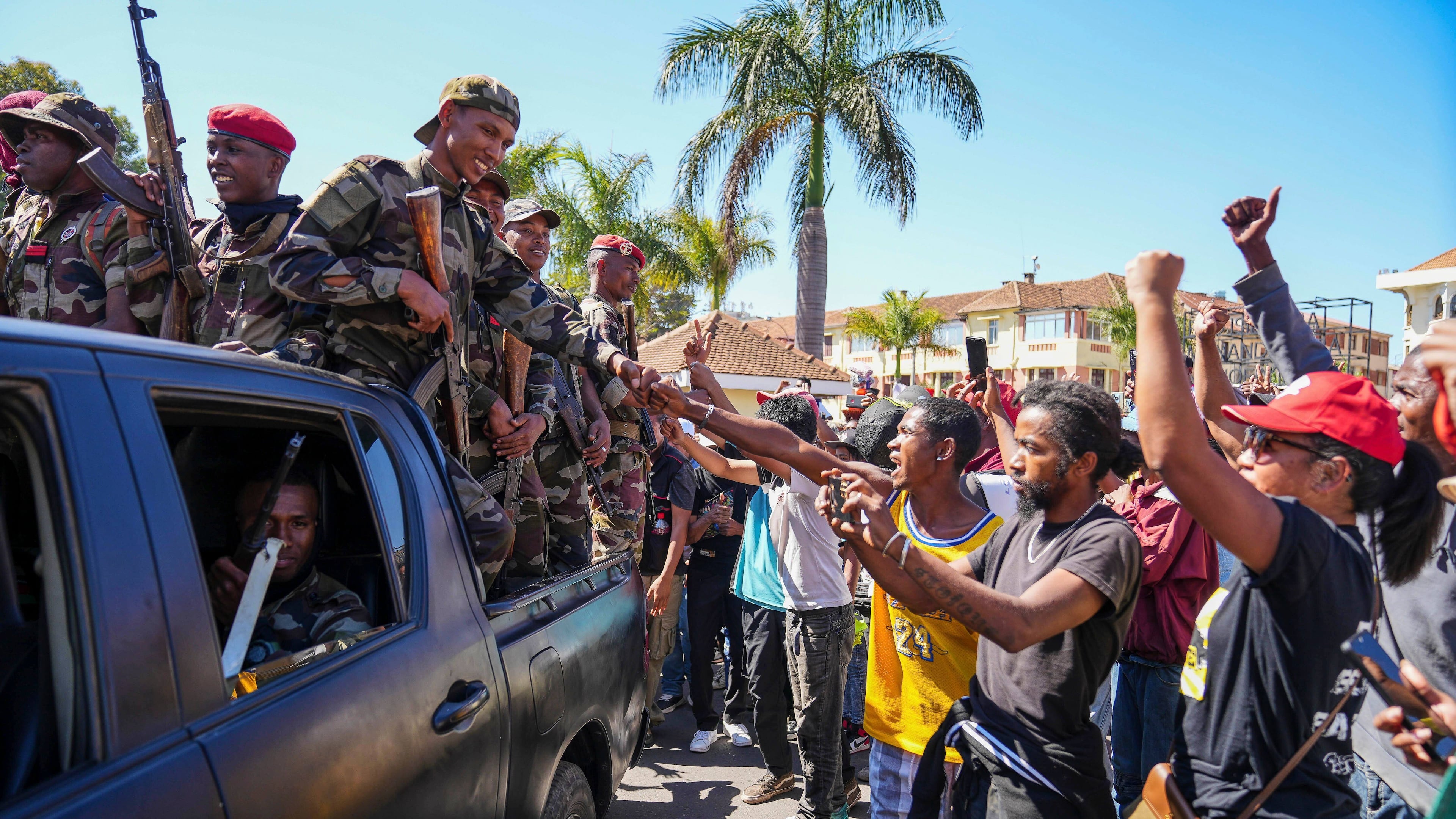 Soldiers are greeted by people gathering for a ceremony in tribute to demonstrators killed during recent anti-government protest in Antananarivo, Madagascar, Sunday, Oct. 12, 2025. (AP Photo/Mamyrael)