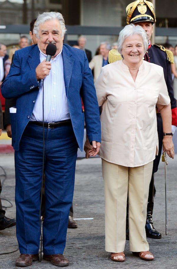 FILE - Uruguay's President Jose Mujica, left, and his wife Lucia Topolansky attend a flag ceremony in Montevideo, Uruguay, Feb. 27, 2015. (AP Photo/Matilde Campodonico, File)