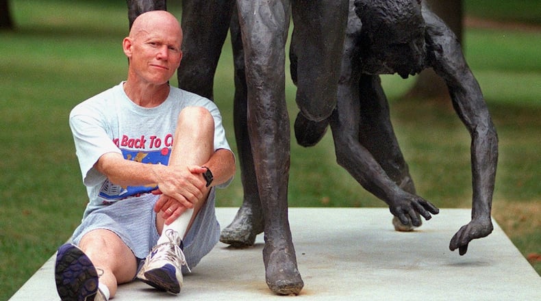 Dick Buerkle posed for this 1998 AJC photo after becoming the oldest winner of the masters division of the Peachtree Road Race. Buerkle sat at the base of "The Last Meter" sculpture in Piedmont Park, which depicts the conclusion of the final of the 5,000 meters at the 1976 Olympics, a race that he qualified for but did not reach the finals. (AJC file photo by Alicia Hansen)