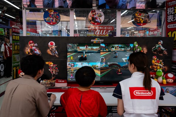 Staff and members of the public try the Nintendo Switch 2 during a launch event at an electronics retailer in Tokyo, Thursday, June 5, 2025. (AP Photo/Louise Delmotte)