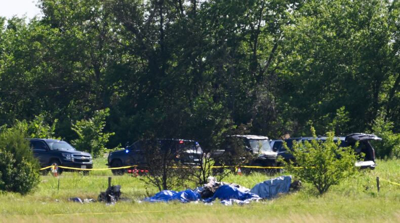 Part of the wreckage of a plane crash is covered with a blue tarp at Butler Memorial Airport in Butler, Mo., Sunday, June 14, 2026. (AP Photo/Reed Hoffmann)
