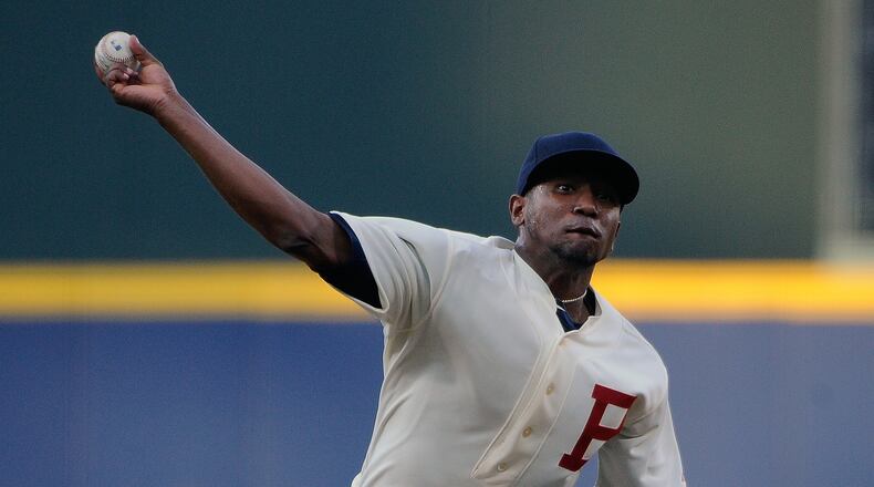 Wearing a 1914 throwback uniform to commemorate the World Series-winning Boston Braves, Atlanta Braves starting pitcher Julio Teheran delivers to the Oakland Athletics during the first inning of a baseball game Saturday, Aug. 16, 2014, in Atlanta. (AP Photo/David Tulis)