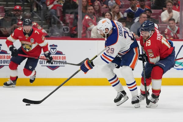 Edmonton Oilers center Leon Draisaitl (29) takes control of the puck as Florida Panthers left wing Matthew Tkachuk (19) defends during the third period of Game 4 of the NHL hockey Stanley Cup Final Thursday, June 12, 2025, in Sunrise, Fla. (AP Photo/Lynne Sladky)