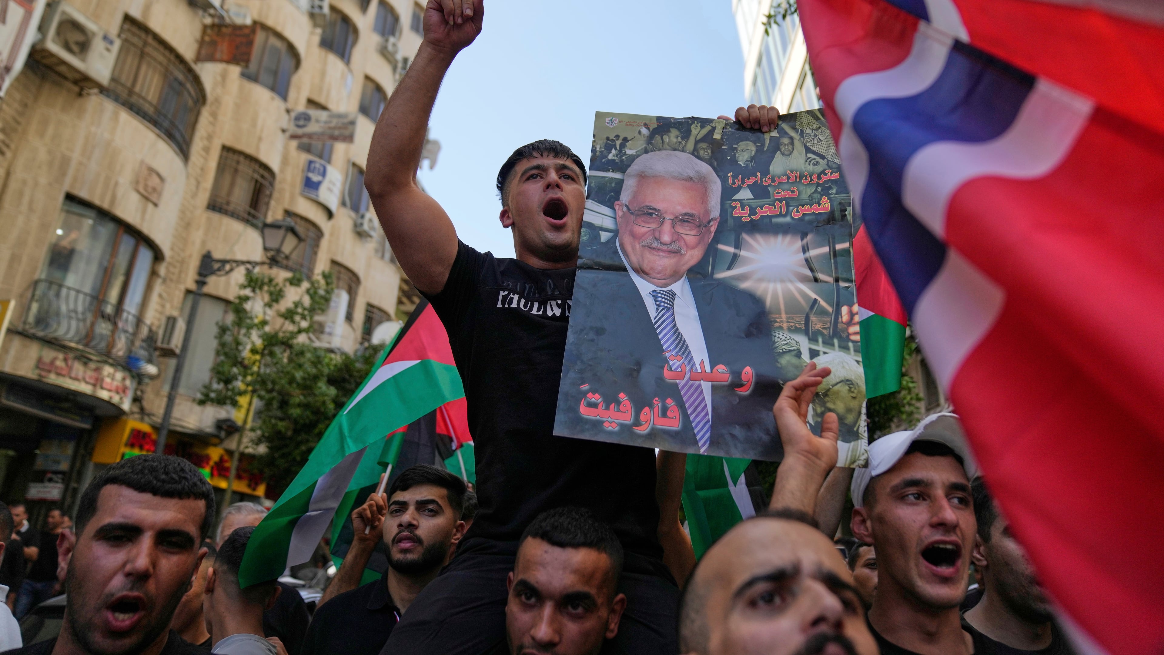 Palestinians chant national slogans and carry posters with pictures of President Mahmoud Abbas and read "you kept your promise," during a rally in support for Gaza and celebrating the latest western nations recognitions of the Palestinian state ahead of the United Nations General Assembly meetings, in the West Bank city of Ramallah Tuesday, Sept. 23, 2025. (AP Photo/Nasser Nasser)