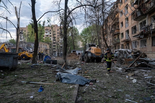 A rescue worker passes the body of a victim after a Russian strike in a residential neighborhood in Kyiv, Ukraine, Thursday, April 24, 2025. (AP Photo/Alex Babenko)