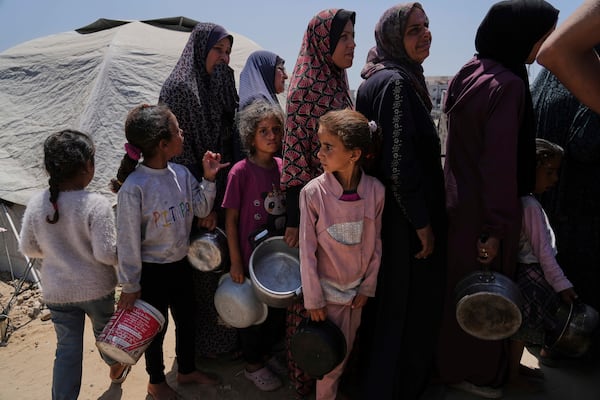 Displaced Palestinians line up to receive donated meals from a community kitchen at a tent camp in Gaza City on Wednesday, May 21, 2025. (AP Photo/Jehad Alshrafi)