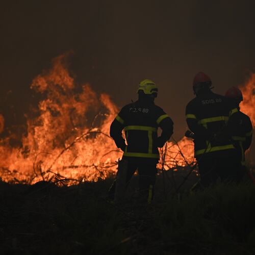Firefighters spray water in a burning forest near Lacanau, southwestern France, Saturday, July 25, 2026. (AP Photo/Emma Da Silva)