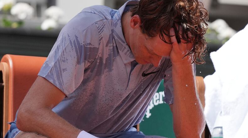 Jannik Sinner of Italy reacts as he cools himself with the water during a break at the second round men's singles tennis match against Juan Manuel Cerundolo of Argentina at the French Open tennis tournament in Paris, Thursday, May 28, 2026, as temperature rises up to 33 C (91 F). (AP Photo/Thibault Camus)