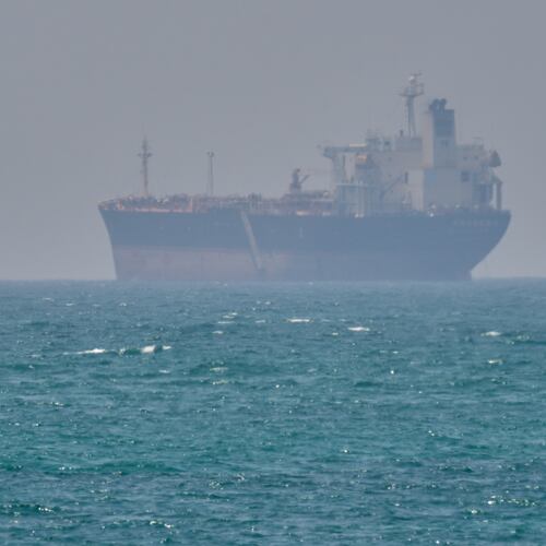 FILE - A boat sails past a tanker anchored on the Strait of Hormuz off the coast Qeshm island, Iran, April 18, 2026. (AP Photo/Asghar Besharati, File)