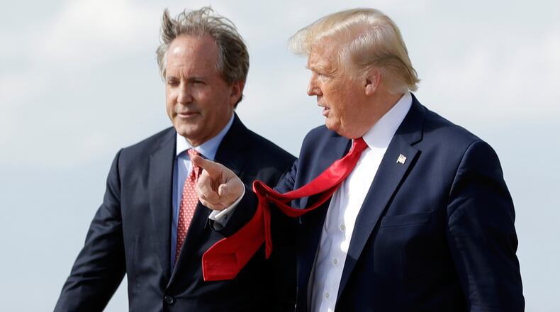 FILE - President Donald Trump walks with Texas Attorney General Ken Paxton, left, at Austin-Bergstrom International Airport in Austin, on Wednesday, Nov. 20, 2019. (AP Photo/Evan Vucci, File)