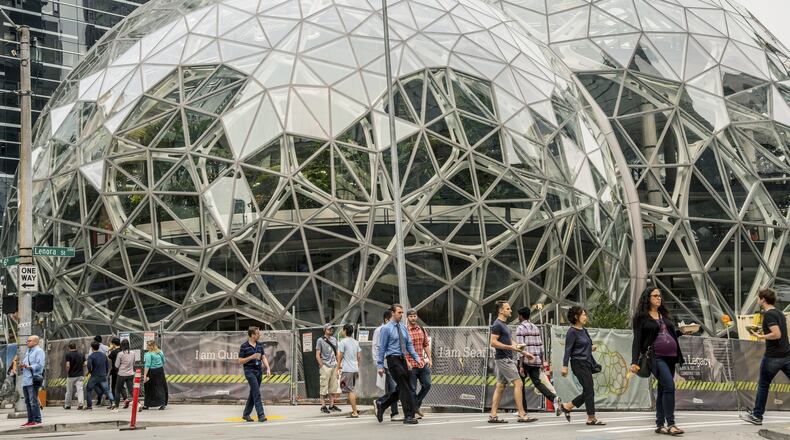 Pedestrians walk past a recently built trio of geodesic domes that are part of the Seattle headquarters for Amazon,. The online retail giant is searching for a second headquarters in North America, a huge new development that would cost as much as $5 billion to build and run, and house as many as 50,000 employees. (Stuart Isett/The New York Times)