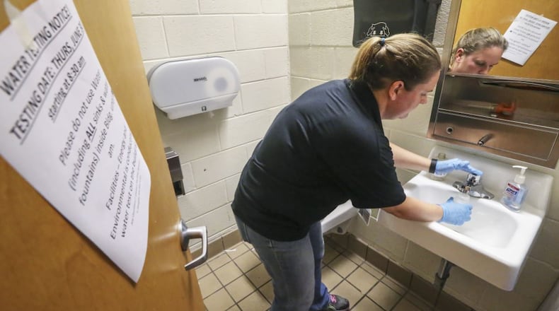 Erin Garmon with Morley Environmental fills containers of water samples from faucets at the Capitol View building at 1442 Metropolitan Pkwy SW in Atlanta on June 30, 2016, one of several Atlanta Public Schools buildings that were tested for lead. JOHN SPINK/jspink@ajc.com
