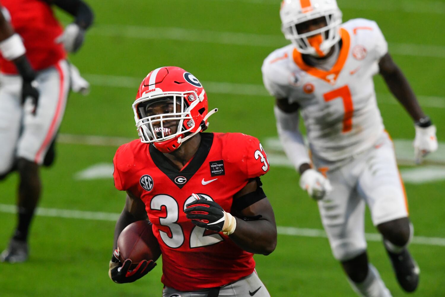 Georgia linebacker Monty Rice (32) runs for a TD as Tennessee wide receiver Brandon Johnson (7) after Rice recovered a fumble which he caused during the second half of a football game on Saturday, Oct. 10, 2020, at Sanford Stadium in Athens. Georgia won 44-21. JOHN AMIS FOR THE ATLANTA JOURNAL- CONSTITUTION