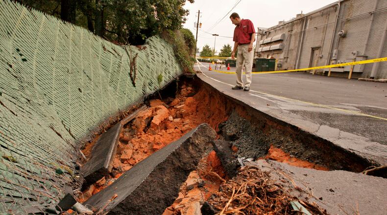 Duron Paints store manager Charles Dima inspects the washed out parking lot in back of the Shamrock shopping center at North Druid Hills Road and Lawrenceville Highway in Dekalb County oin Sept. 17, 2009. Overnight rains washed away a large portion of the lot into the backyard of a resident on Mt. Olive Drive that shares the property line with the center. John Spink / jspink@ajc.com