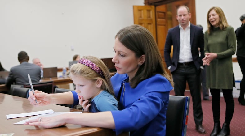 Stacey Evans, with her 6-year-old daughter Ashley on her lap, fills out the paperwork to qualify for the governor's race in 2018. BOB ANDRES / BANDRES@AJC.COM