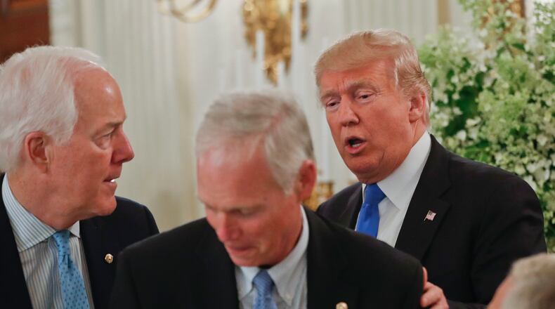 President Donald Trump stops to greet Senate Majority Whip John Cornyn of Texas, left, and Sen. Ron Johnson, R-Wis. at a luncheon with GOP leadership on Wednesday in the White House. AP/Pablo Martinez Monsivais