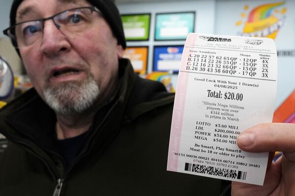 Pete Gruber holds a Mega Millions lottery ticket at Mares Mart in Chicago, Sunday, April 6, 2025. (AP Photo/Nam Y. Huh)