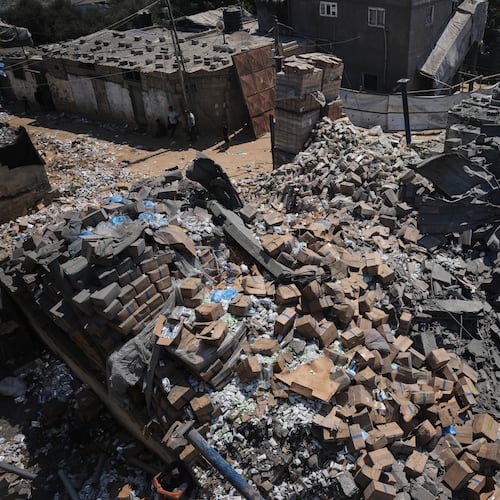 Palestinians walk past a food-aid warehouse damaged in an Israeli airstrike that targeted a nearby house in Deir al-Balah, central Gaza Strip, Wednesday, Aug. 26, 2026. (AP Photo/Abdel Kareem Hana)