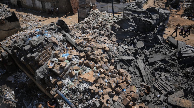 Palestinians walk past a food-aid warehouse damaged in an Israeli airstrike that targeted a nearby house in Deir al-Balah, central Gaza Strip, Wednesday, Aug. 26, 2026. (AP Photo/Abdel Kareem Hana)