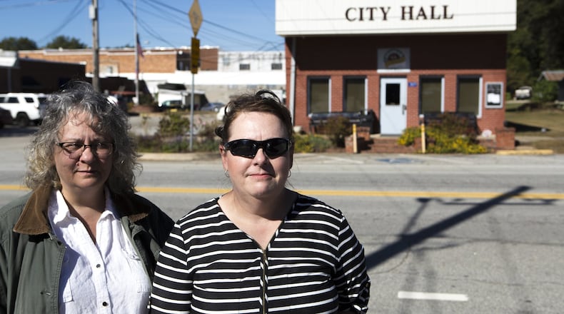 Sondra Moore (left), 47, of Hoschton, Ga., and Catherine Corkren, 47, of Atlanta, pose for a portrait across the road from Statham City Hall in Statham, Ga., on Wednesday, Oct. 24, 2018. Because of open criticism of what they call wrongdoing by the city, Corkren, Moore and a third person were banned from the city of Statham. The ban against Moore has since been lifted, while the ban against Corkren remains in effect pending the outcome of a case against it in federal court.
