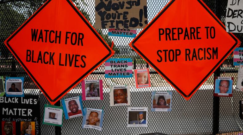 These sgns were placed on the fence in front of the White House in Washington during racial inequality protests last summer. (Yuri Gripas/Abaca Press/TNS)