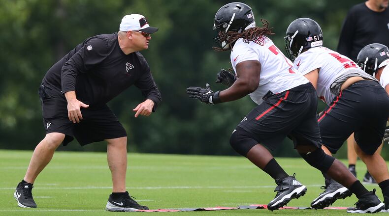 Down in the trenches: Offensive line coach Chris Morgan gets in some work with guard James Carpenter during Wednesday's minicamp practice in Flowery Branch. (Curtis Compton/ccompton@ajc.com).