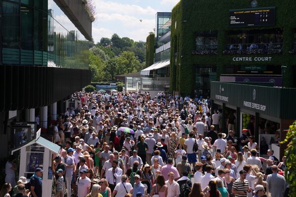 Spectators arrive for the Wimbledon Tennis Championships in London, Monday, June 30, 2025. (AP Photo/Kin Cheung)