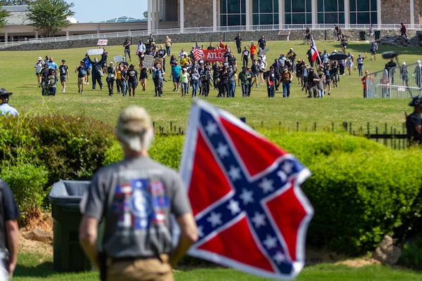 Members of the Sons of Confederate Veterans were met by counterprotesters - the two sides separated by a fence - during a rally to mark Confederate Memorial Day at Stone Mountain Park on Saturday, April 30, 2022. (Steve Schaefer/AJC)