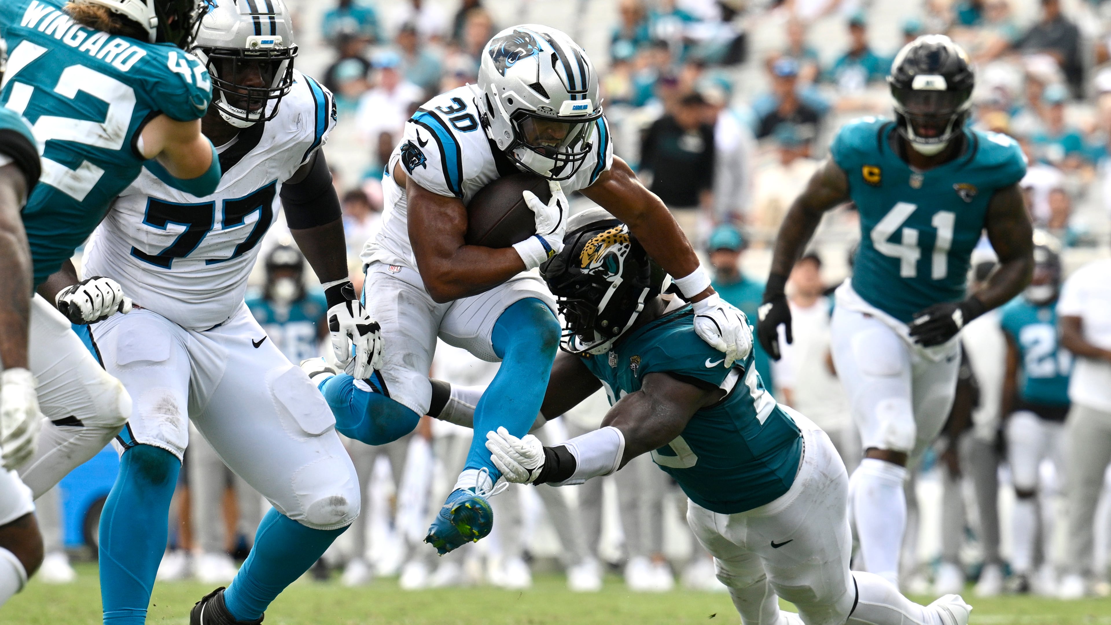 Carolina Panthers running back Chuba Hubbard runs the ball against Jacksonville Jaguars linebacker Foyesade Oluokun, center right, during the second half of an NFL football game, Sunday, Sept. 7, 2025, in Jacksonville, Fla. (Phelan M. Ebenhack/AP)