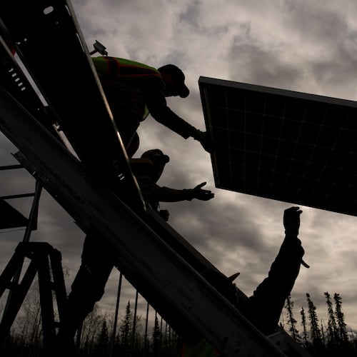 FILE - Workers install panels at a solar project May 21, 2025, in Galena, Alaska. (AP Photo/John Locher, File)