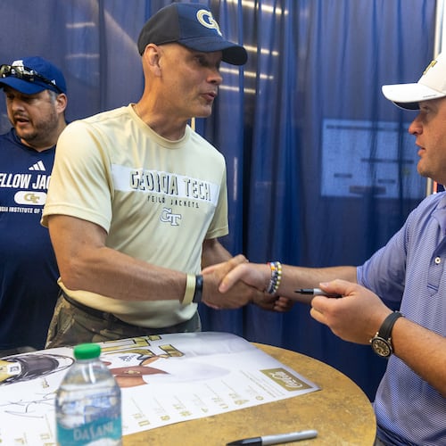 Georgia Tech coach Brent Key (right) shakes hands with Alan Womack after Key signed his poster during Georgia Tech football’s annual First Saturday on The Flats at Bobby Dodd Stadium on July 27, 2024. (Steve Schaefer / AJC)