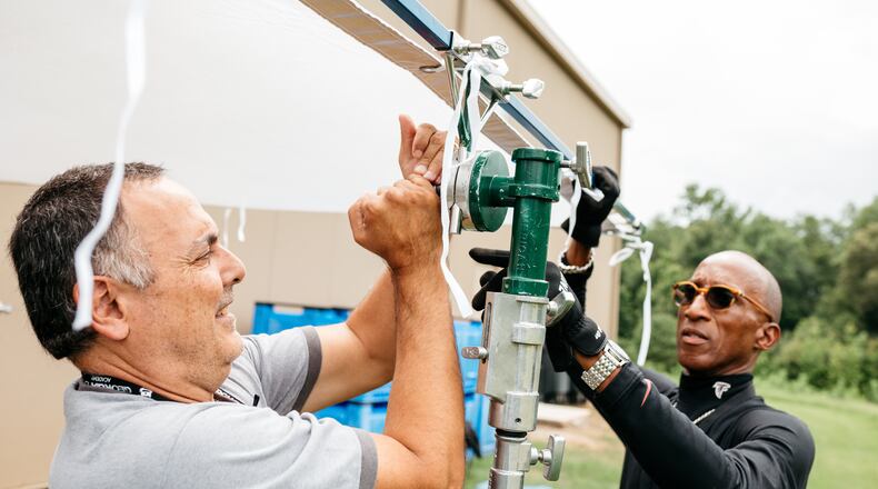 Aldo Bacallao, a broadcast video teacher at North Springs Charter High School, and Allen Norwood, at teacher at Tri-Ciities High School's Department Mission: CTAE News The Career, Technical, and Agricultural Education Department, mount an 8x8 overhead into a large gobo head on a combo stand during their Georgia Film Academy training. Photo: Kyle Sudu