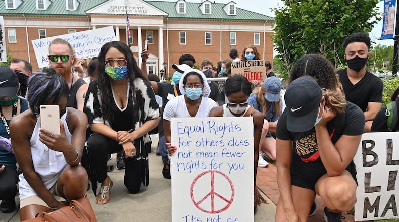 Demonstrators kneel in a moment of silence outside the Forsyth County courthouse in Cumming during a peaceful protest for unity and equality in June 2020. Efforts continue in the county to make sure its troubled past, which included a cleansing of Black residents more than a century ago, isn't forgotten. (Hyosub Shin / Hyosub.Shin@ajc.com)