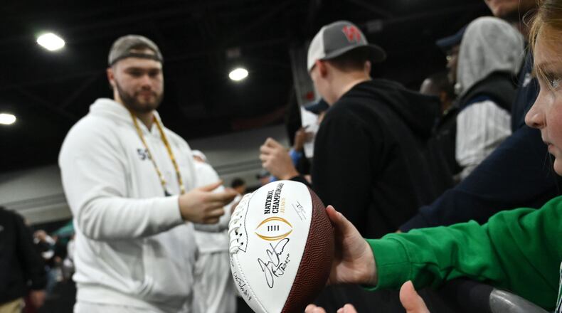 A young fan waits to get an autograph from Notre Dame offensive lineman Rocco Spindler (50) during Media Day at the Georgia World Congress Center ahead of the 2025 College Football Playoff national championship game between Notre Dame and Ohio State on Saturday, Jan. 18, 2025, in Atlanta. (Hyosub Shin/AJC)