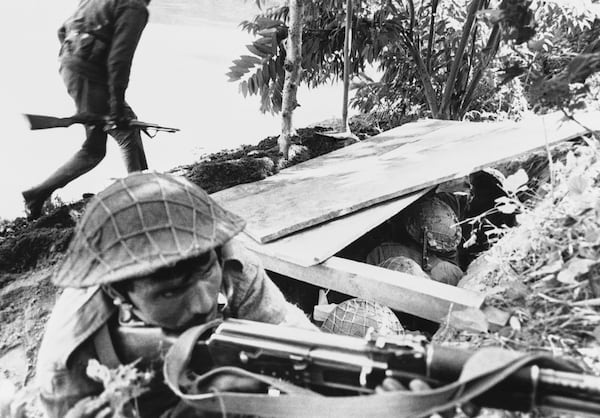 FILE - A Pakistani soldier aims his rifle as a fellow soldier runs for cover during Indian shelling of Pakistani positions in the Jessore area of East Pakistan on Dec. 2, 1971. (AP Photo, File)