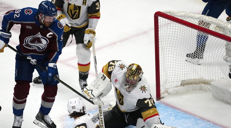 Vegas Golden Knights goaltender Carter Hart, right, stops a shot off the stick of Colorado Avalanche left wing Gabriel Landeskog during the third period in Game 1 of the Western Conference finals NHL hockey Stanley Cup playoff series Wednesday, May 20, 2026, in Denver. (AP Photo/David Zalubowski)