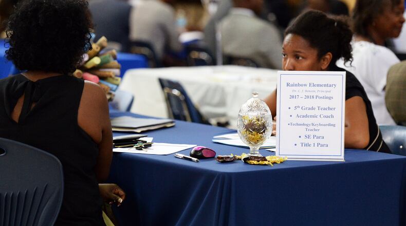 At a DeKalb Schools job fair last year, a candidate talks with a representative of Rainbow Elementary. The district is holding a job fair Dec. 7 at DeKalb Early College Academy in Stone Mountain.