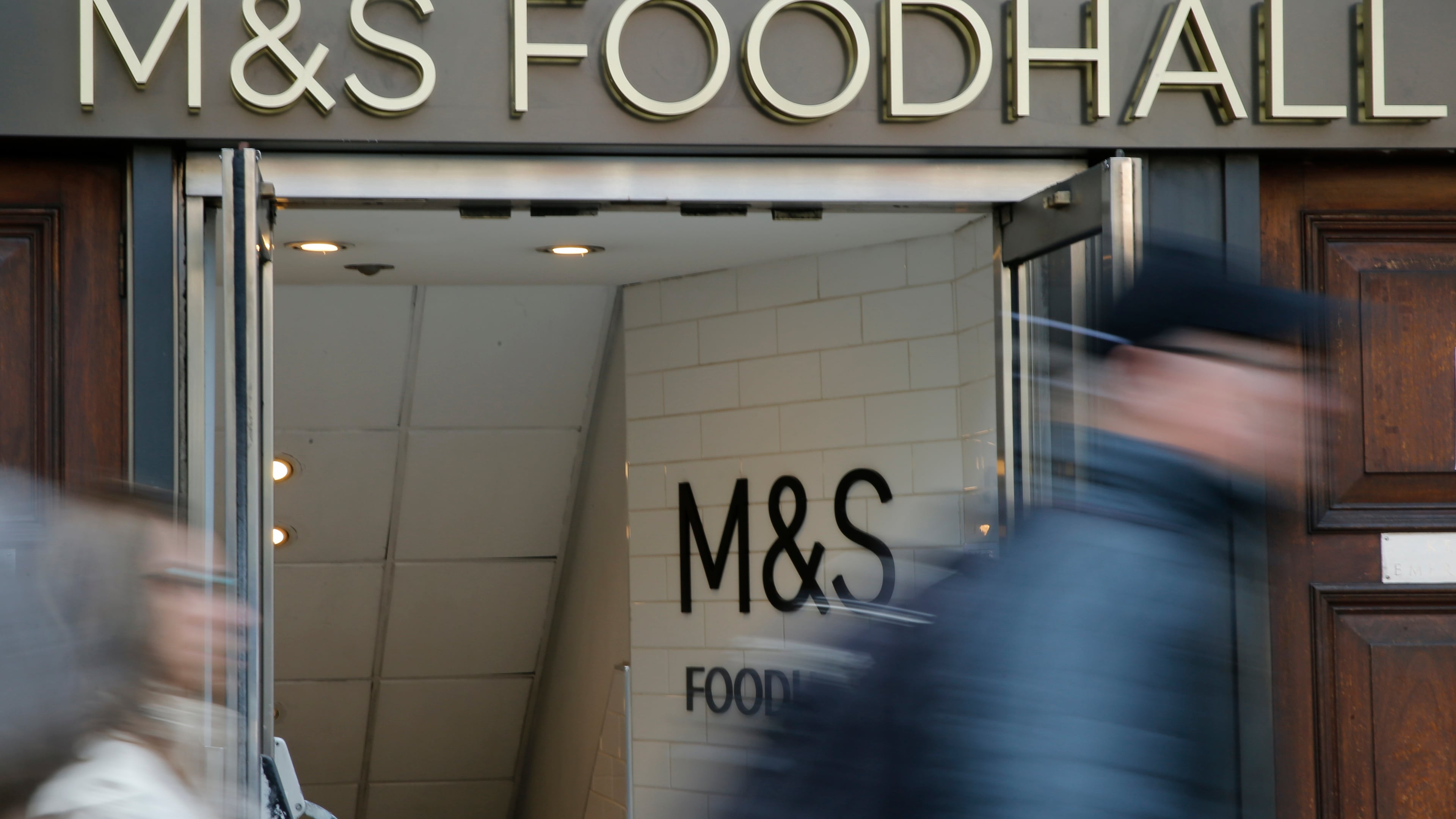 People walk past a branch of British clothing and food store Marks and Spencer in London, Wednesday, May 23, 2018. (AP Photo/Alastair Grant)