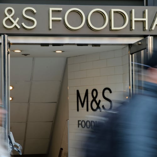 People walk past a branch of British clothing and food store Marks and Spencer in London, Wednesday, May 23, 2018. (AP Photo/Alastair Grant)