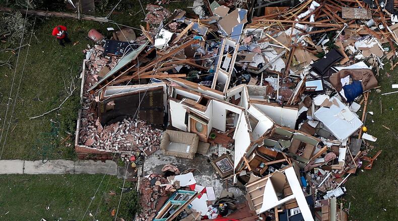 A man stands next to a destroyed home after a tornado tore through the eastern neighborhood of New Orleans, Tuesday, Feb. 7, 2017. Louisiana Gov. John Bel Edwards took an aerial tour before meeting New Orleans officials. He says the path of destruction is wide and varied. In eastern New Orleans, he says "it kind of bounced back and forth" across the busy Chef Menteur Highway. (AP Photo/Gerald Herbert)