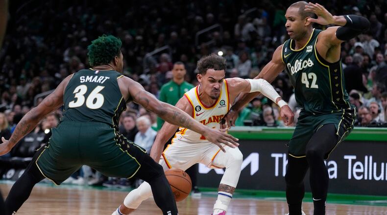 Atlanta Hawks guard Trae Young, center, drives to the basket against Boston Celtics guard Marcus Smart (36) and center Al Horford (42) during the first half of Game 5 in a first-round NBA basketball playoff series Tuesday, April 25, 2023, in Boston. (AP Photo/Charles Krupa)