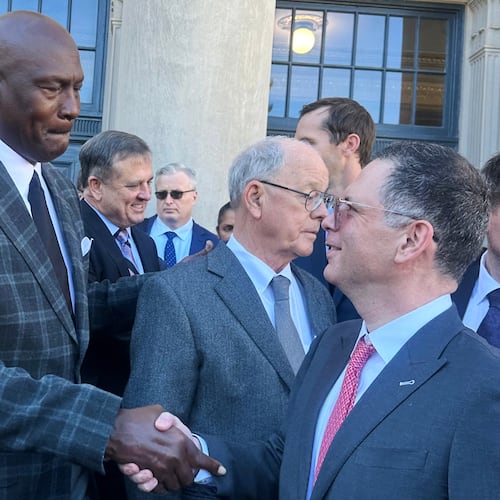 Michael Jordan, left, shakes hands with NASCAR attorney Lawrence Buterman as NASCAR chairman Jim France, center, looks away, Thursday, Dec. 11, 2025, outside the federal courthouse in Charlotte, N.C. (AP Photo/Jenna Fryer)