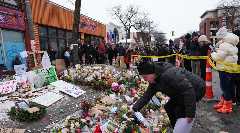 People visit a makeshift memorial for 37-year-old Alex Pretti, who was fatally shot by a U.S. Border Patrol officer over the weekend, Monday, Jan. 26, 2026, in Minneapolis. (AP Photo/Adam Gray)
